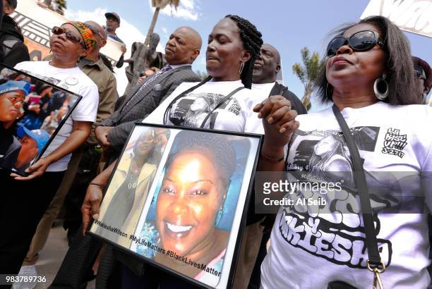 Lisa Hines, center, Mother of Wakiesha Wilson, a black woman who was found dead in a LAPD jail in 2016, holds a photo of her daughter as she holds...