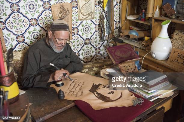 Moroccan Omer al-Hadi draws a calligraphy of Turkish President Recep Tayyip Erdogan on a leather after his presidential election success in Kenitra,...