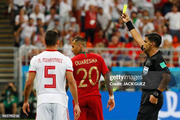 Paraguayan referee Enrique Caceres presents a yellow card to Portugal's forward Ricardo Quaresma during the Russia 2018 World Cup Group B football...