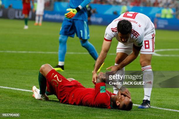 Iran's defender Morteza Pouraliganji checks up on Portugal's forward Ricardo Quaresma following a challenge during the Russia 2018 World Cup Group B...
