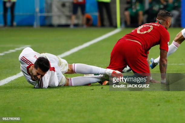Portugal's forward Ricardo Quaresma tackles Iran's midfielder Saeid Ezatolahi during the Russia 2018 World Cup Group B football match between Iran...
