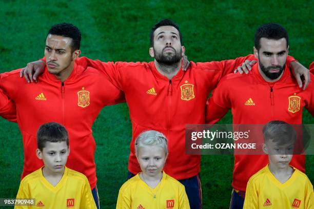 Spain's midfielder Thiago Alcantara, Spain's midfielder Isco and Spain's defender Dani Carvajal listen to their national anthem before the Russia...