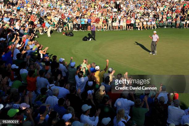 Tiger Woods celebrates making birdie on the 18th hole in front of a gallery of fans during the third round of the 2010 Masters Tournament at Augusta...