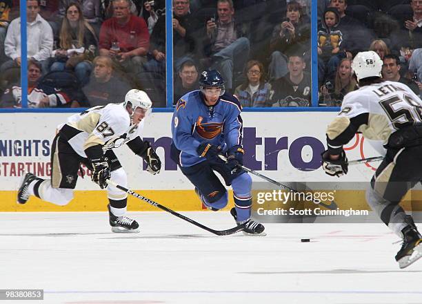 Evander Kane of the Atlanta Thrashers carries the puck against Sidney Crosby of the Pittsburgh Penguins at Philips Arena on April 10, 2010 in...