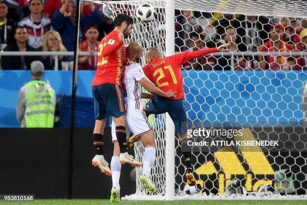 Morocco's forward Noureddine Amrabat jumps for the ball between Spain's midfielder Isco and Spain's forward David Silva during the Russia 2018 World...