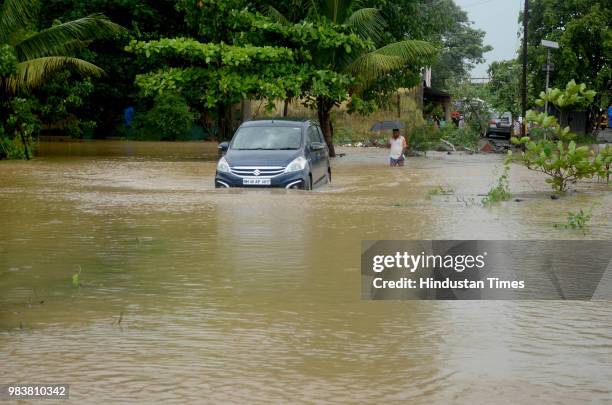 Car make its way through flooded road with rain waters in Ganeshpuri Village at Navi Mumbai International Airport Site on June 25, 2018 in Navi...