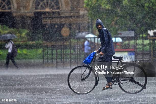 People deals with rain at Mumbai CST on June 25, 2018 in Mumbai, India. Heavy downpour led to waterlogging at several places including roads in and...