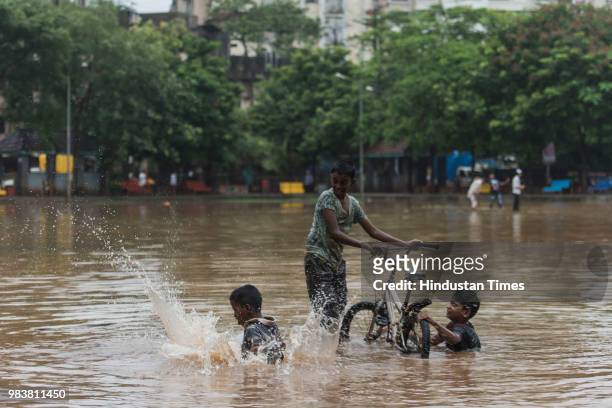 Kids play in a submerged ground after the heavy rains at Chembur on June 25, 2018 in Mumbai, India. Heavy downpour led to waterlogging at several...