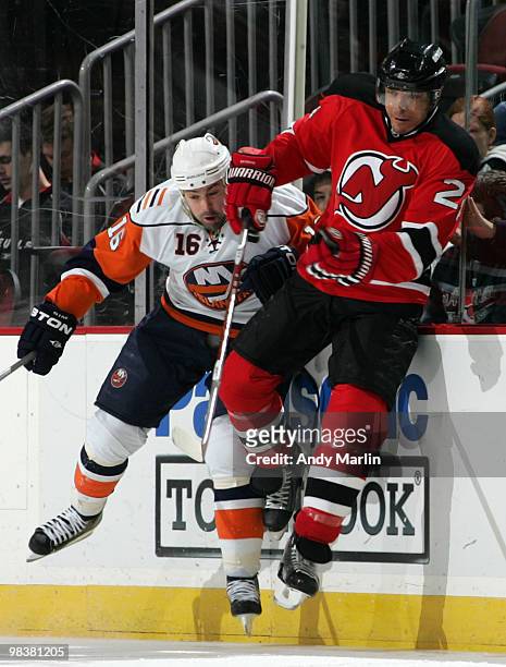 Jon Sim of the New York Islanders and Bryce Salvador of the New Jersey Devils come together hard against the boards during the game at the Prudential...