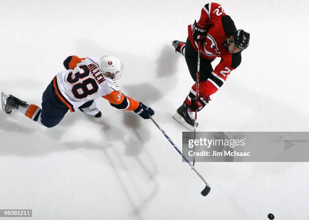 Mike Mottau of the New Jersey Devils shoots the puck as Jack Hillen of the New York Islanders defends at the Prudential Center on April 10, 2010 in...