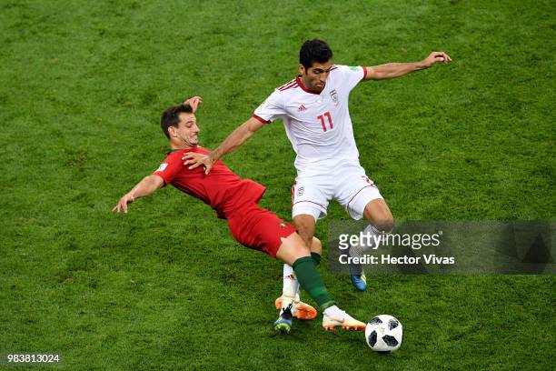 Cedric of Portugal tackles Vahid Amiri of Iran during the 2018 FIFA World Cup Russia group B match between Iran and Portugal at Mordovia Arena on...