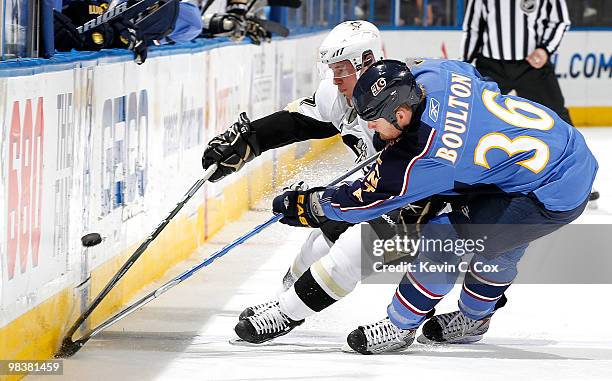 Sidney Crosby of the Pittsburgh Penguins battles for the puck against Eric Boulton of the Atlanta Thrashers at Philips Arena on April 10, 2010 in...