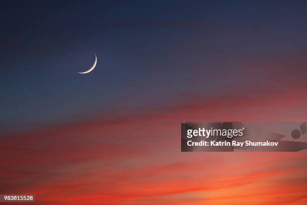 crescent moon in glowing sunset skies - red cloud sky stock pictures, royalty-free photos & images