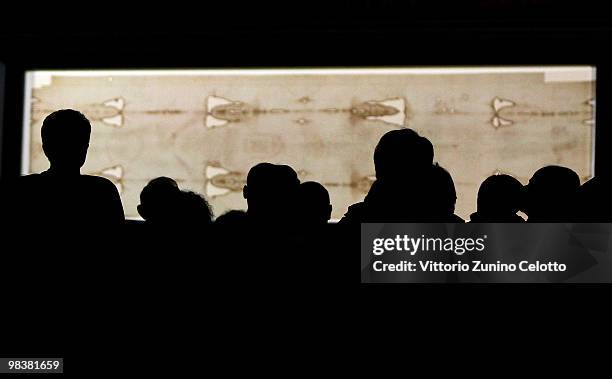 People stand in front of the Holy Shroud during the Solemn Exposition Of The Holy Shroud on April 10, 2010 in Turin, Italy. The Holy Shroud will be...