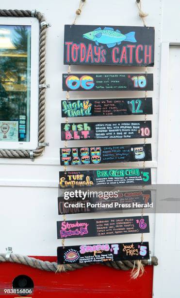 The menu board for Fishin Ships during opening night of Congdon's After Dark, a gathering of food trucks at Congdon's Donuts in Wells, on Thursday,...