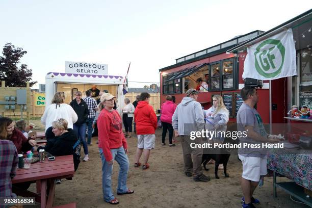 People look over their options and wait for their meals during the opening night of Congdon's After Dark, a gathering of food trucks at Congdon's...