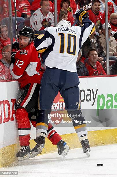 Mike Fisher of the Ottawa Senators is bodychecked into the boards by Henrik Tallinder of the Buffalo Sabres at Scotiabank Place on April 10, 2010 in...