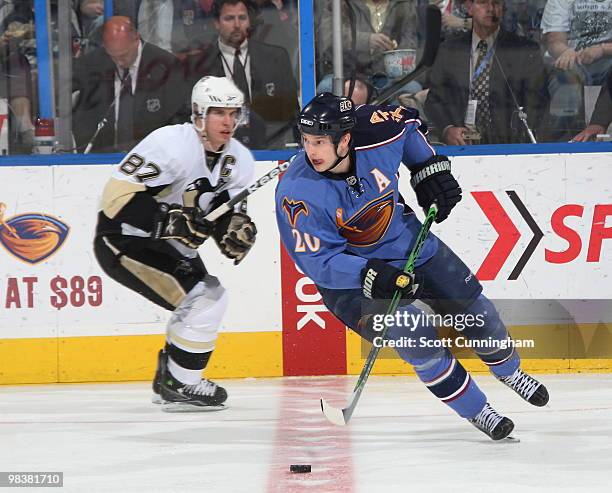 Colby Armstrong of the Atlanta Thrashers carries the puck against Sidney Crosby of the Pittsburgh Penguins at Philips Arena on April 10, 2010 in...