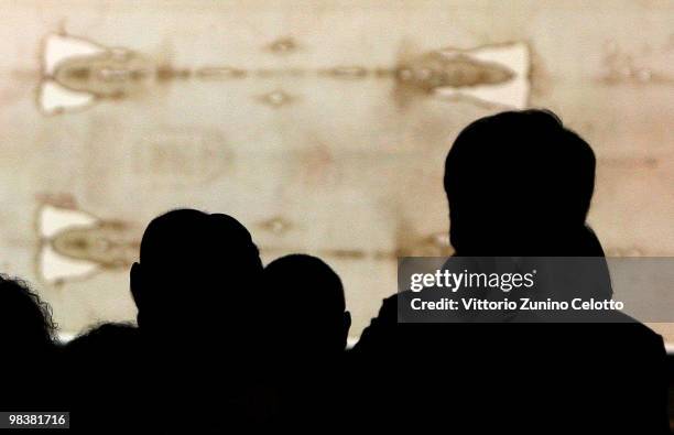 People stand in front of the Holy Shroud during the Solemn Exposition Of The Holy Shroud on April 10, 2010 in Turin, Italy. The Holy Shroud will be...