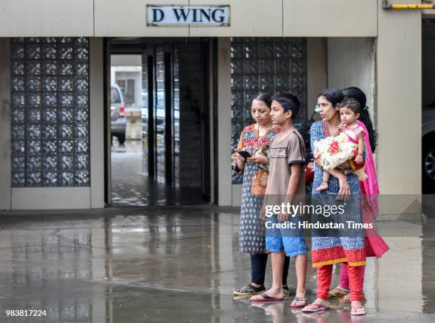 Residents of Lloyd's Estate watch as several cars struck in debris after a wall collapsed at a construction site in Antop Hill, Wadala East area on...