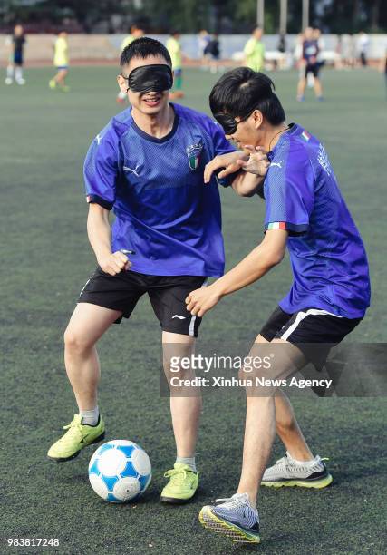 June 25, 2018 -- Sun Dongyuan and Fan Changjie play football at the special education school of Changchun University in northeast China's Jilin...