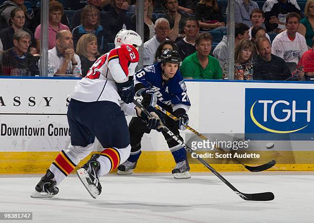 Martin St. Louis of the Tampa Bay Lightning passes the puck against Jason Garrison of the Florida Panthers at the St. Pete Times Forum on April 10,...