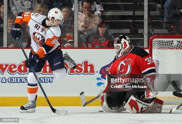 Martin Brodeur of the New Jersey Devils makes a save as John Tavares of the New York Islanders looks for the rebound at the Prudential Center on...