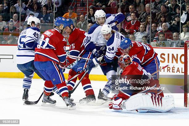 Jaroslav Halak of the Montreal Canadiens stosp the puck in front of members of the Toronto Maple Leafs during the NHL game on April 10, 2010 at the...