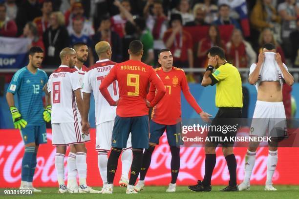 Spain's forward Iago Aspas speaks with Uzbek referee Ravshan Irmatov as he waits for Spain's second goal confirmation by the VAR during the Russia...