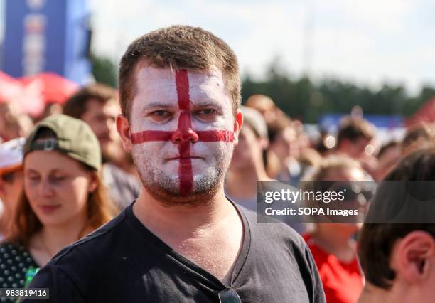 Fan of the England national team seen with his face painted in the colors of the national flag.