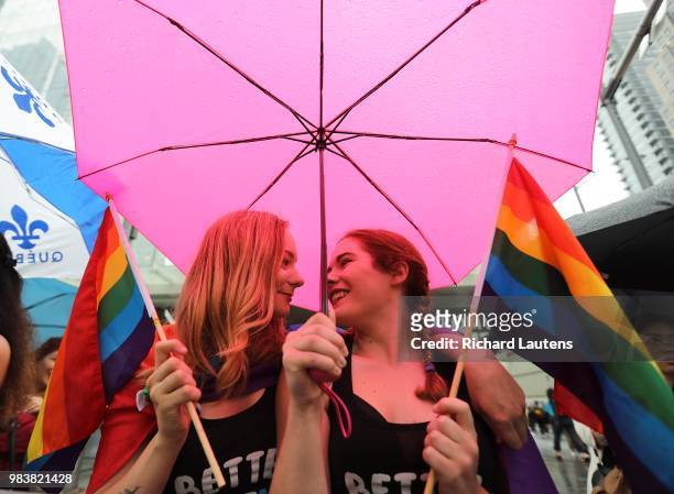 June 24: Girlfriends , Mackenzie Leclaire and Sarah Dargie stay dry under their pink umbrella while watching the parade. Hundreds of thousands came...