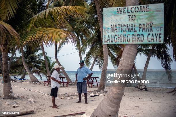 Men remain at the Laughing Bird Caye National Park in the outskirts of Placencia village, in Stann Creek District, Belize, on June 6, 2018. - Backed...