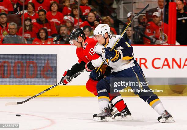 Toni Lydman of the Buffalo Sabres leans into Jason Spezza of the Ottawa Senators while he tries to carry the puck to the net in a game at Scotiabank...