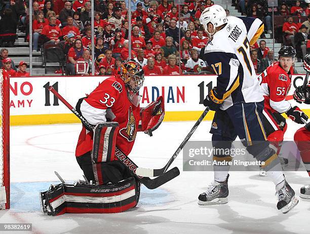 Pascal Leclaire of the Ottawa Senators makes a save as Raffi Torres of the Buffalo Sabres charges in for a rebound at Scotiabank Place on April 10,...