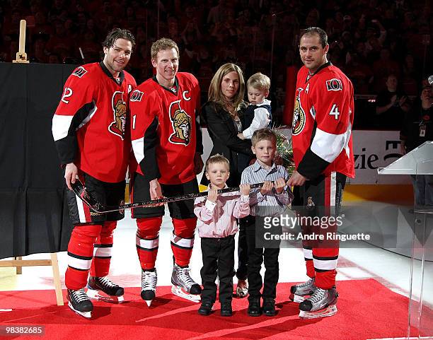 Daniel Alfredsson poses with his family as Mike Fisher and Chris Phillips of the Ottawa Senators present him with a silver stick during a celebration...