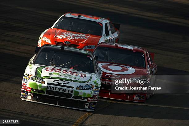 Tony Stewart, driver of the Office Depot/Old Spice Chevrolet, drives ahead of Juan Pablo Montoya, driver of the Target Chevrolet, and Joey Logano,...