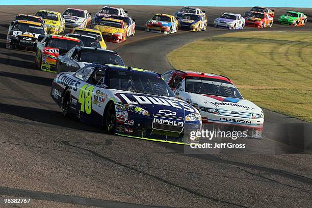 Jimmie Johnson, driver of the Lowe's Chevrolet, and AJ Allmendinger, driver of the Valvoline Ford, lead a pack of cars during the NASCAR Sprint Cup...