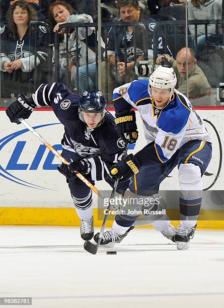 Jay McClement of the St. Louis Blues carries the puck past Dustin Boyd of the Nashville Predators on April 10, 2010 at the Bridgestone Arena in...
