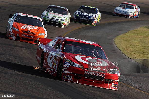 Juan Pablo Montoya, driver of the Target Chevrolet, drives ahead of Joey Logano, driver of the The Home Depot Toyota, and a pack of cars during the...