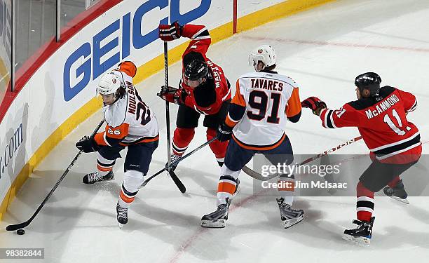 Matt Moulson and John Tavares of the New York Islanders control the puck against Paul Martin and Dean McAmmond of the New Jersey Devils at the...