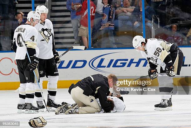 Jordan Leopold, Jordan Staal and Kris Letang of the Pittsburgh Penguins watch as a trainer tends to Matt Cooke after he was injured during a fight...