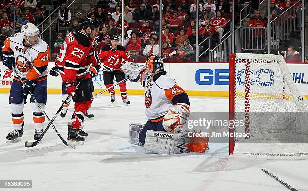 David Clarkson of the New Jersey Devils watches as the puck gets past Martin Biron of the New York Islanders for a goal from teammate Brian Rolston...