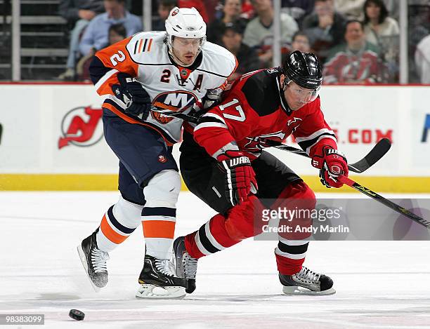 Mark Streit of the New York Islanders and Ilya Kovalchuk of the New Jersey Devils battle hard for position on a loose puck during the game at the...