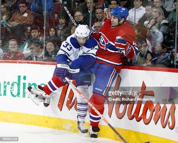 Luca Caputi of the Toronto Maple Leafs body checks Roman Hamrlik of the Montreal Canadiens during the NHL game on April 10, 2010 at the Bell Centre...