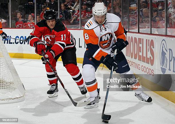 Bruno Gervais of the New York Islanders controls the puck against Dean McAmmond of the New Jersey Devils at the Prudential Center on April 10, 2010...
