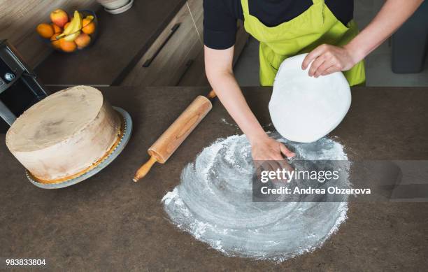 woman using rolling pin preparing white fondant for cake decorating, hands detail, view from above - rolling pin stock-fotos und bilder