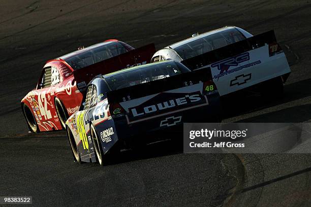Juan Pablo Montoya, driver of the Target Chevrolet, drives ahead of Bobby Labonte, driver of the TRG Motorsports Chevrolet, and Jimmie Johnson,...