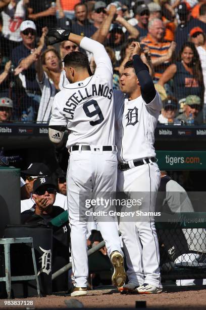 Nicholas Castellanos of the Detroit Tigers celebrates his three run seventh inning home run with Jose Iglesias while playing the Oakland Athletics at...