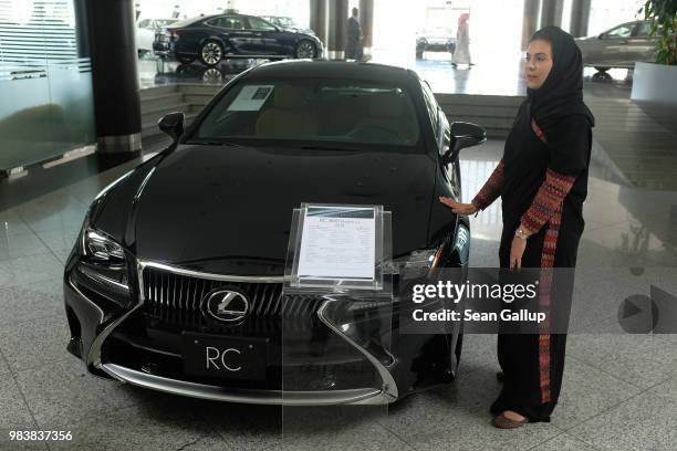 Modia Batterjee touches a Lexus car she is interested in buying at a Lexus dealership the day after women are once again allowed to drive in Saudi...