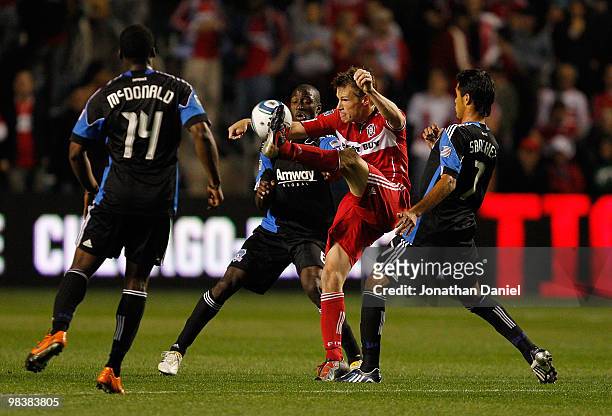 Brian McBride of the Chicago Fire kicks the ball between Brandon McDonald, Ike Opara and Ramon Sanchez of the San Jose Earthquakes in an MLS match on...